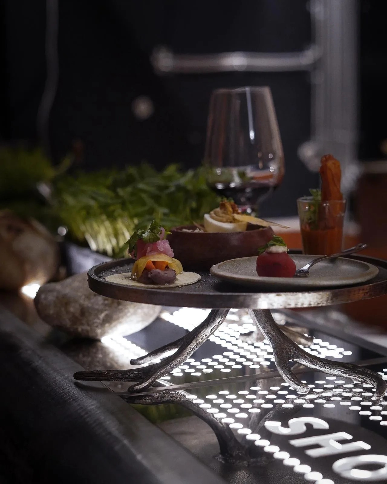Vin și tapas prezentate pe barul iluminat.